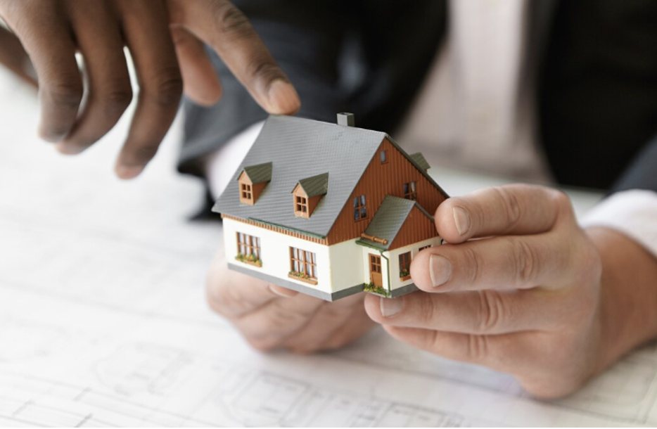 Realtor Holding a Miniature House